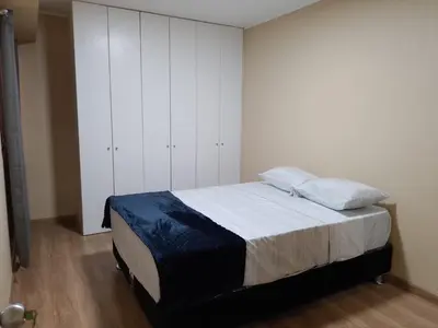 a bedroom with a bed and white cabinets at Cozy Central Apartment Ideal for Work & Travel in Lima