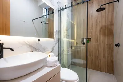 a bathroom with a sink and a glass shower at Sol de Paracas Beach Homes by Vibrant in Pisco