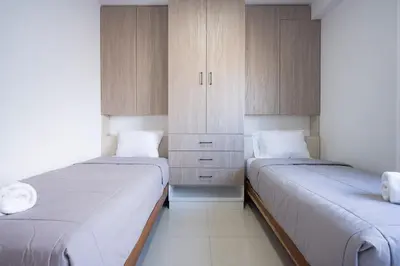 two beds in a room with wooden cabinets at Sol de Paracas Beach Homes by Vibrant in Pisco