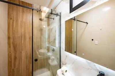 a bathroom with a glass shower and a sink at Sol de Paracas Beach Homes by Vibrant in Pisco