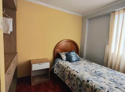 a bedroom with a bed with a blue pillow on it at Wasin Kusi in Ayacucho