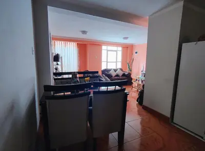 a living room with a couch and a table and chairs at Wasin Kusi in Ayacucho