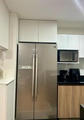 a kitchen with a stainless steel refrigerator and a microwave at Modern room by the sea in Lima