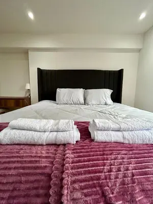 two towels sitting on top of a large bed at Modern room by the sea in Lima