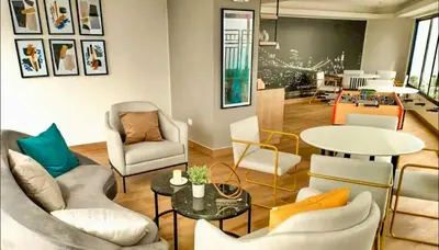 a living room with chairs and a table at Modern room by the sea in Lima
