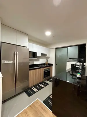 a kitchen with a stainless steel refrigerator and a table at Modern room by the sea in Lima