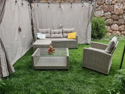 a patio with a couch and two chairs and a table at UMAY lodge house in Urubamba