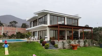 a large white house with a pool in a yard at Welcome to our Pachacamac retreat in Pachacamac
