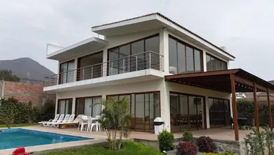 a house with a balcony and a swimming pool at Welcome to our Pachacamac retreat in Pachacamac