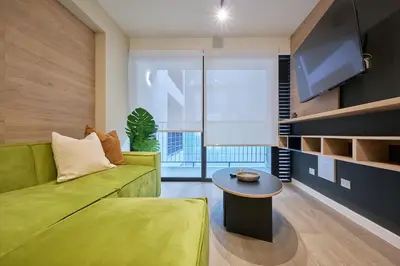 a living room with a green couch and a table at Saturn by Geko in Lima