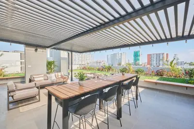 a large wooden table and chairs on a balcony at Saturn by Geko in Lima