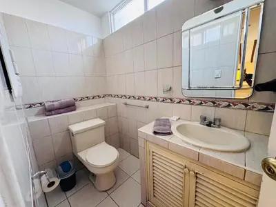 a bathroom with a toilet and a sink and a mirror at M25 Duplex a media cuadra Embajada de USA in Lima