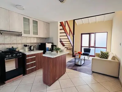 a kitchen with a stove and a couch in a room at M25 Duplex a media cuadra Embajada de USA in Lima
