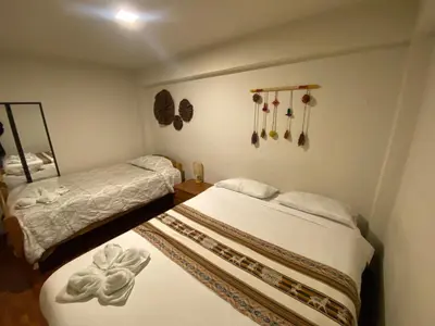 a bedroom with two beds and a mirror at Cozy aparts & rooms in Cusco