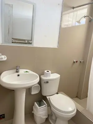 a bathroom with a toilet and a sink and a mirror at HOSPEDAJE VISTA Del SOL PARACAS in Paracas