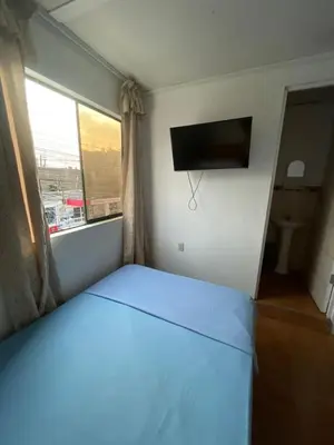 a bedroom with a bed and a flat screen tv at HOSPEDAJE VISTA Del SOL PARACAS in Paracas