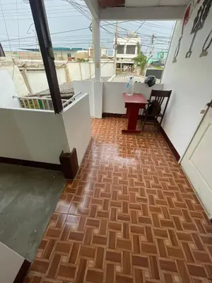 a balcony with a wooden floor and a table at HOSPEDAJE VISTA Del SOL PARACAS in Paracas