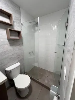 a bathroom with a toilet and a glass shower at Moderno Departamento en Lima - Chorrillos in Lima