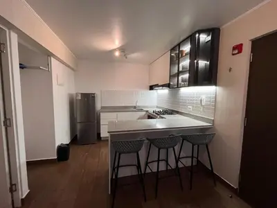 a kitchen with a counter and some chairs in it at Moderno Departamento en Lima - Chorrillos in Lima