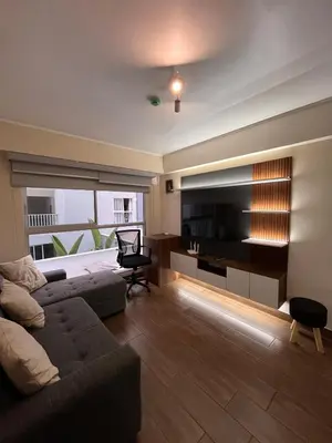 a living room with a couch and a television at Moderno Departamento en Lima - Chorrillos in Lima