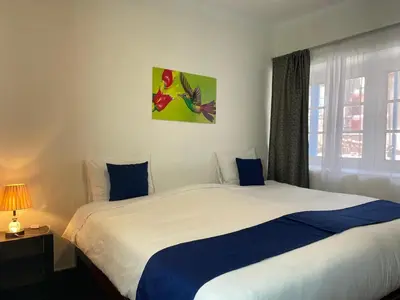 a bedroom with a bed with blue and white sheets at Runa House2 in Cusco