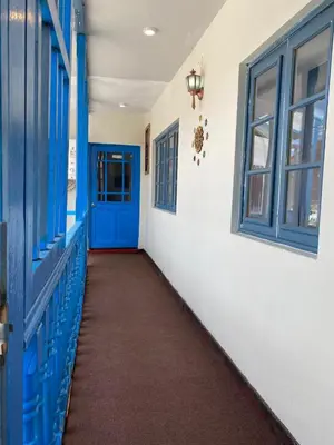 a hallway with a blue door and windows at Runa House2 in Cusco