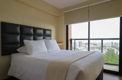a bedroom with a large bed with a large window at Stunning 2BR with Balcony & City Views in Lima