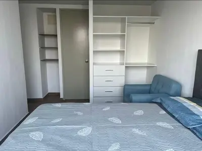 a bedroom with a bed and a blue chair at Departamento cómodo a 20 minutos del aeropuerto in Lima