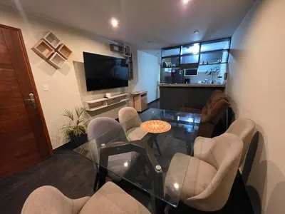 a living room with a glass table and chairs at Departamento Surquillo INEN in Lima