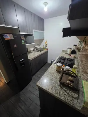 a kitchen with a black refrigerator and a counter at Departamento Surquillo INEN in Lima