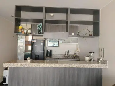 a kitchen with a counter top and a refrigerator at Departamento Surquillo INEN in Lima