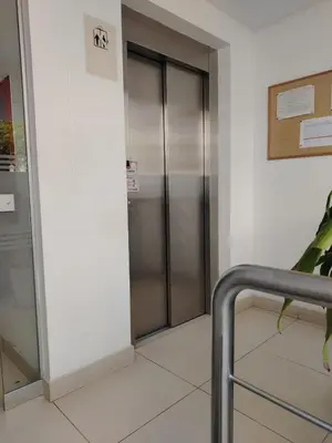an elevator in a building with a sign on the wall at Departamento Surquillo INEN in Lima