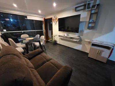 a living room with a couch and a table and a television at Departamento Surquillo INEN in Lima