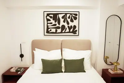 a bedroom with a bed with white sheets and green pillows at 1BDR Modern apartment in Barranco in Lima