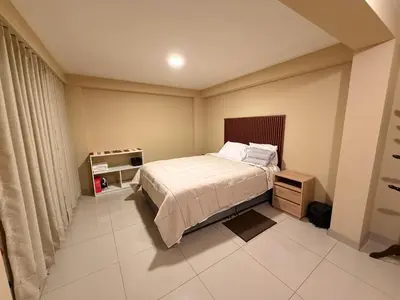 a small bedroom with a bed and a night stand at Tres Cruces Private Rooms in Cusco