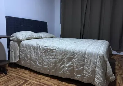 a bed with a white comforter in a bedroom at Rustic Getaway in San Bartolo in San Bartolo