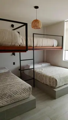 a bedroom with two bunk beds and a window at Punta Caleta Punta Hermosa in Punta Hermosa