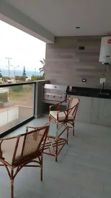 two chairs and a glass table on a balcony at Punta Caleta Punta Hermosa in Punta Hermosa