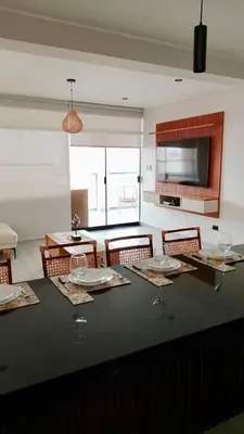 a dining room with a table with chairs and a television at Punta Caleta Punta Hermosa in Punta Hermosa