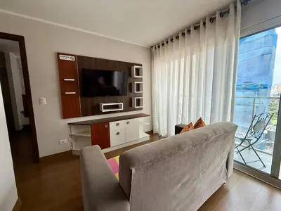 a living room with a couch and a television at Departamento Graña in Lima
