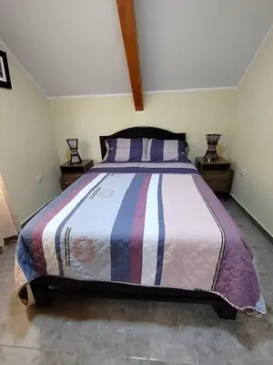 a bedroom with a bed with a colorful comforter at La Casa de ANNI in Oxapampa