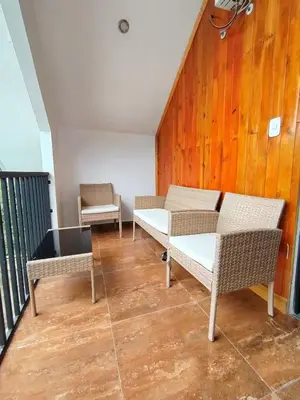 a group of chairs and tables on a balcony at La Casa de ANNI in Oxapampa