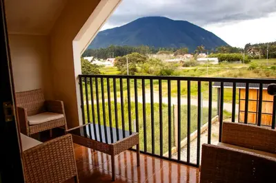 a balcony with chairs and a view of a mountain at La Casa de ANNI in Oxapampa