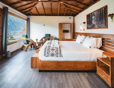 a bedroom with a large bed and a table at Tara Vegan Lodge - Sacred Valley in Urubamba