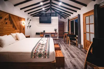 a bedroom with a large bed and a desk at Tara Vegan Lodge - Sacred Valley in Urubamba