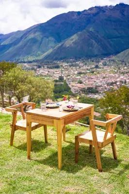 a picnic table and two chairs sitting on top of a hill at Tara Vegan Lodge - Sacred Valley in Urubamba