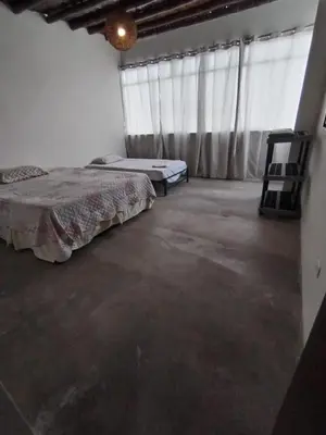 a bedroom with two beds and two chairs in it at Apartment facing Mirador Analí in Punta Hermosa