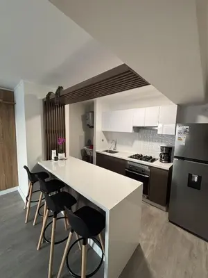 a kitchen with a counter and some chairs in it at 2BR Apartment with Pool near Larcomar in Lima