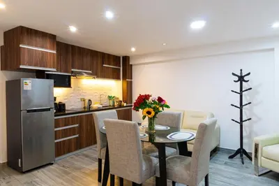 a kitchen and dining room with a table and a refrigerator at Lama Vista Living 302 in Cusco