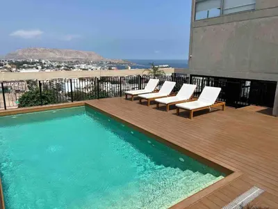 a swimming pool with lounge chairs on a balcony at Barranco Bohemio, Modern and Bright Apartment in Lima